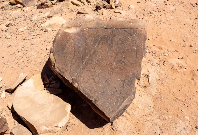 A fallen inscribed sandstone block resting on the desert floor, Wadi Rum